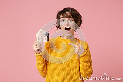 Shocked young brunette woman girl in yellow sweater posing isolated on pastel pink background in studio. People Stock Photo