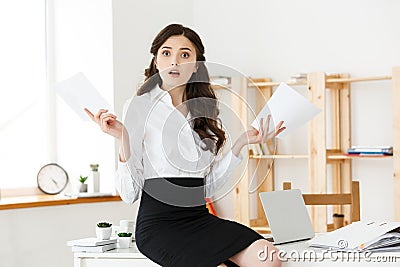 Shocked young business woman surprised by reading unexpected news in document, amazed woman office worker feeling Stock Photo