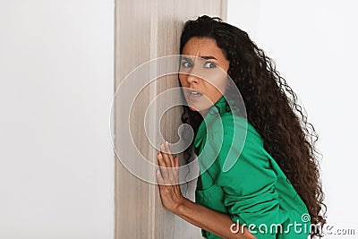 Shocked young lady listening through the door Stock Photo