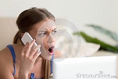 Lady looks shocked when hearing news on cellphone Stock Photo