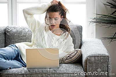 Shocked woman looking at laptop unpleasantly surprised by bad ne Stock Photo