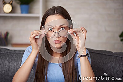 Shocked young woman is wearing round glasses Stock Photo