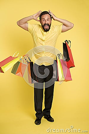 Shocking discount. Man shouting face dropping shopping bags. Guy shocked surprised face dropped bunch bags. Total sale Stock Photo