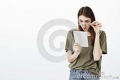 Shocking news in network impressed young girl. Portrait of surprised charming female, taking off glasses and staring Stock Photo