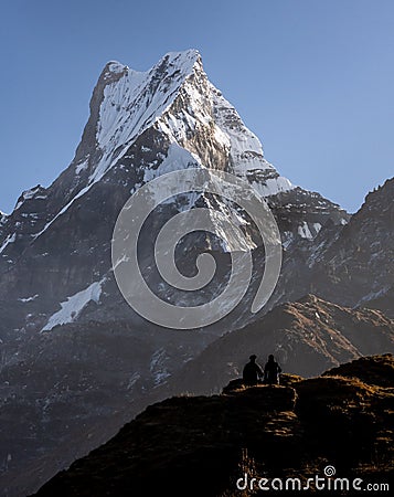 Shocking view of Fish Tail peak and two trekkers as seen from Mardi Himal trekking Stock Photo