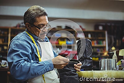 Shoemaker applying glue on shoe Stock Photo