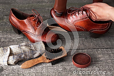 Shoemaker applying shoe shiner on shoe Stock Photo