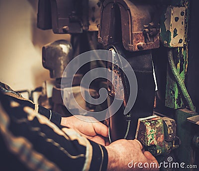 Shoemaker performs shoes in studio craft professional machines. Stock Photo