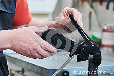 Shoemaker repair female spike shoe. glueing heel Stock Photo