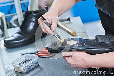 Shoemaker repair shoe. Glueing the sole for male footwear Stock Photo