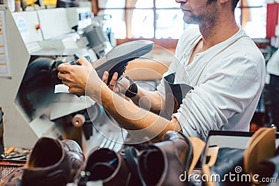 Shoemaker roughing the sole of a leather shoe Stock Photo