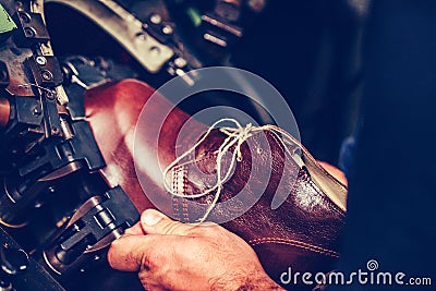 Shoemaker using a special machine for putting shoes on the mold in the footwear industry Stock Photo