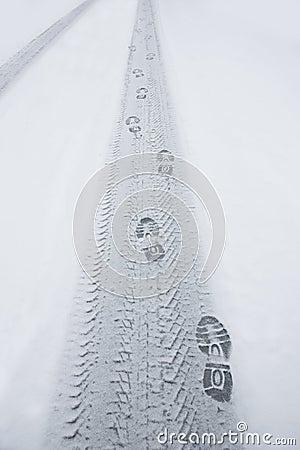 Shoeprints and tire print in snow Stock Photo