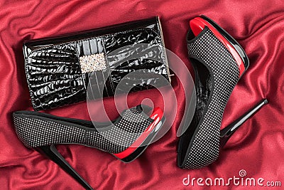 Shoes and bag lying on red fabric Stock Photo