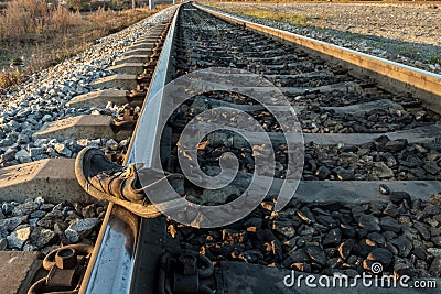 Shoes dirty and old lying on rails, railway accident, sunset in autumn Stock Photo