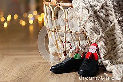 Shoes filled with sweets on floor in room, space for text. Saint Nicholas Day Stock Photo
