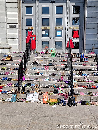 Shoes and teddy bears left on kingston city hall steps in memory of 215 children's graves found in kamloops Editorial Stock Photo