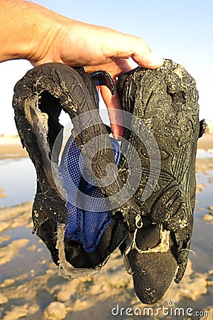 Shoes in the water that did not resist walking on the sea cliff Stock Photo