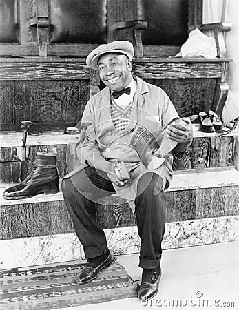 Shoeshine man working and smiling Stock Photo