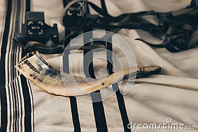 Shofar on a tallit with black stripes, next to tefillin Stock Photo