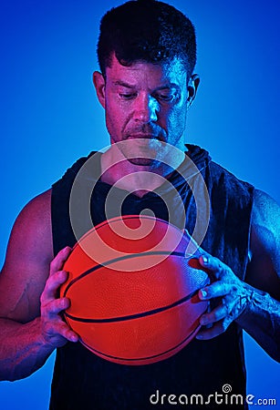 Shoot your shot. Blue filtered shot of a sportsman posing with a basketball in the studio. Stock Photo