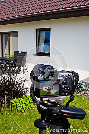 Shooting house exterior, photographer camera, tripod and ballhead Stock Photo