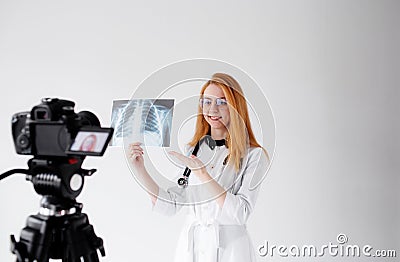 Shooting for a medical video blog. A female doctor smiles and records a training video for her subscribers and patients Stock Photo