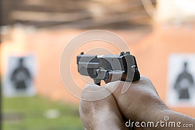 Shooting with a pistol. Man aiming pistol in shooting range. Stock Photo