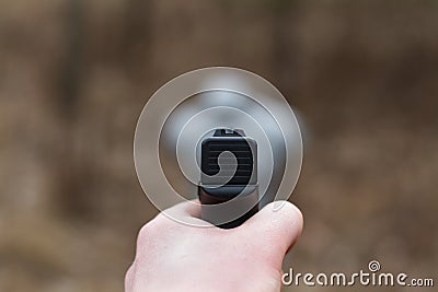 Shooting from a pistol. Reloading the gun. The man is aiming at the target. Shooting range. Man firing usp pistol at target in ind Stock Photo