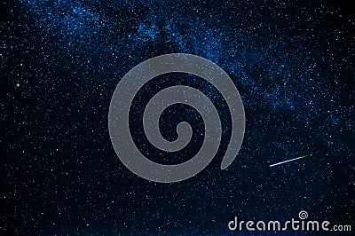 Shooting star in background a starry blue dark sky Stock Photo