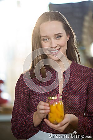 Shop assistant holding a jar of pickle in grocery shop Stock Photo