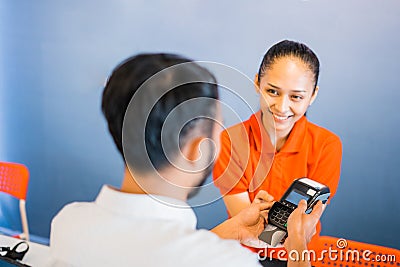 shop assistant invites customers to press the pin on the EDC device Stock Photo