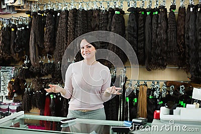 Shop friendly pleasant woman posing at counter with artificial Stock Photo