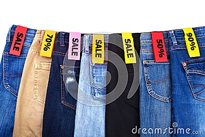 Shop sale of clothes, jeans of different colors blue, green, black on white background isolated close up Stock Photo