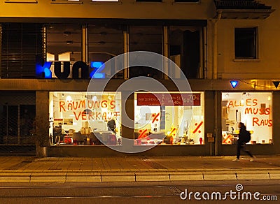 Shop window lighting at night, passing girl, streetview, discount numbers, sale, Editorial Stock Photo