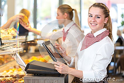 Shopkeeper at bakery working at cash register Stock Photo