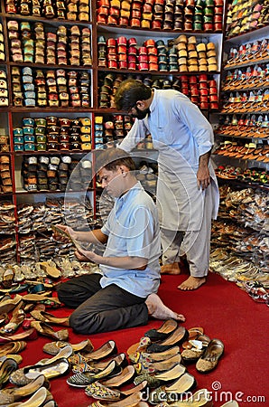 Shopkeepers tend to shoe shop selling hand made leather khussas Karachi Pakistan Editorial Stock Photo