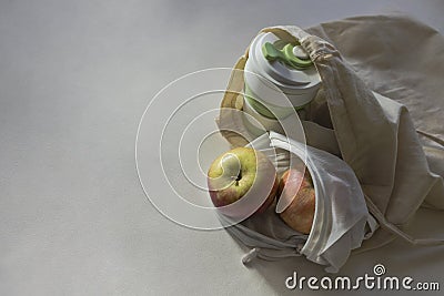 Shopper bag with collapsible silicone mug and apples in reusable fruit pouch Stock Photo