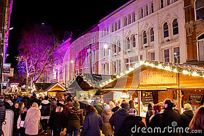 Shoppers enjoy the food and drink huts at the German Christmas market in Birmingham Editorial Stock Photo