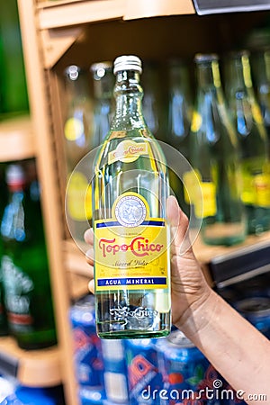 Shoppers hand holding a bottle of topo chico Editorial Stock Photo