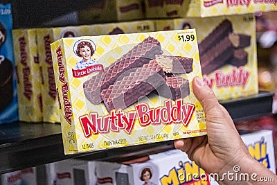 Shoppers hand holding a box of little Debbie Nutty Buddy brand crunchy wafer bars with peanut butter Editorial Stock Photo