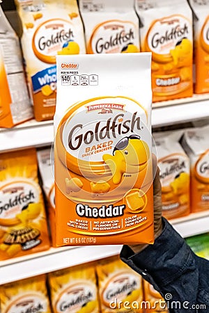 Shoppers hand holding a Package of Assorted Goldfish brand baked crackers Editorial Stock Photo