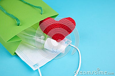 Shopping bag with hand sanitizer, medical face mask and heart symbol. covid-19 stockpile concept Stock Photo