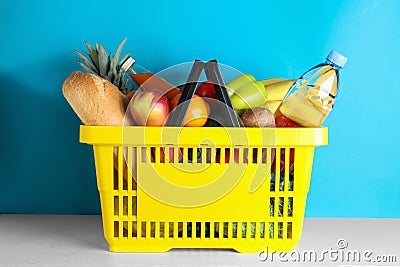 Shopping basket with grocery products on white table Stock Photo