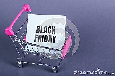 Shopping cart and black friday text on paper tear. Gray background with copy space Stock Photo