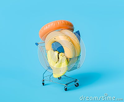 Shopping Cart with Colorful Pool Floats on Blue Background Stock Photo