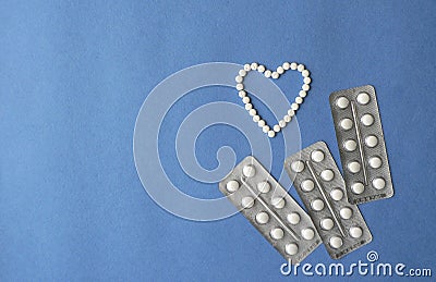 Shopping cart and Heart symbol made from pills on blue background. Treatment of heart disease and of hope for recovery. Creative i Stock Photo