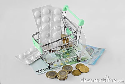 Shopping cart with medicine pills on money - Pharmaceutical cost Stock Photo