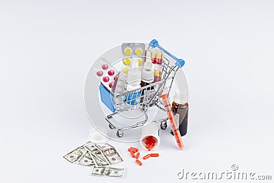 Shopping cart with medicines and moneys on white background Stock Photo