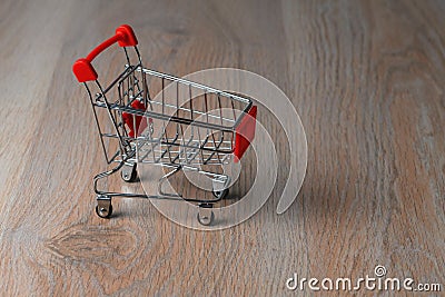 Shopping cart minimalist style. Shopping cart in the supermarket. Sale, discount, the concept of shopaholism. Stock Photo